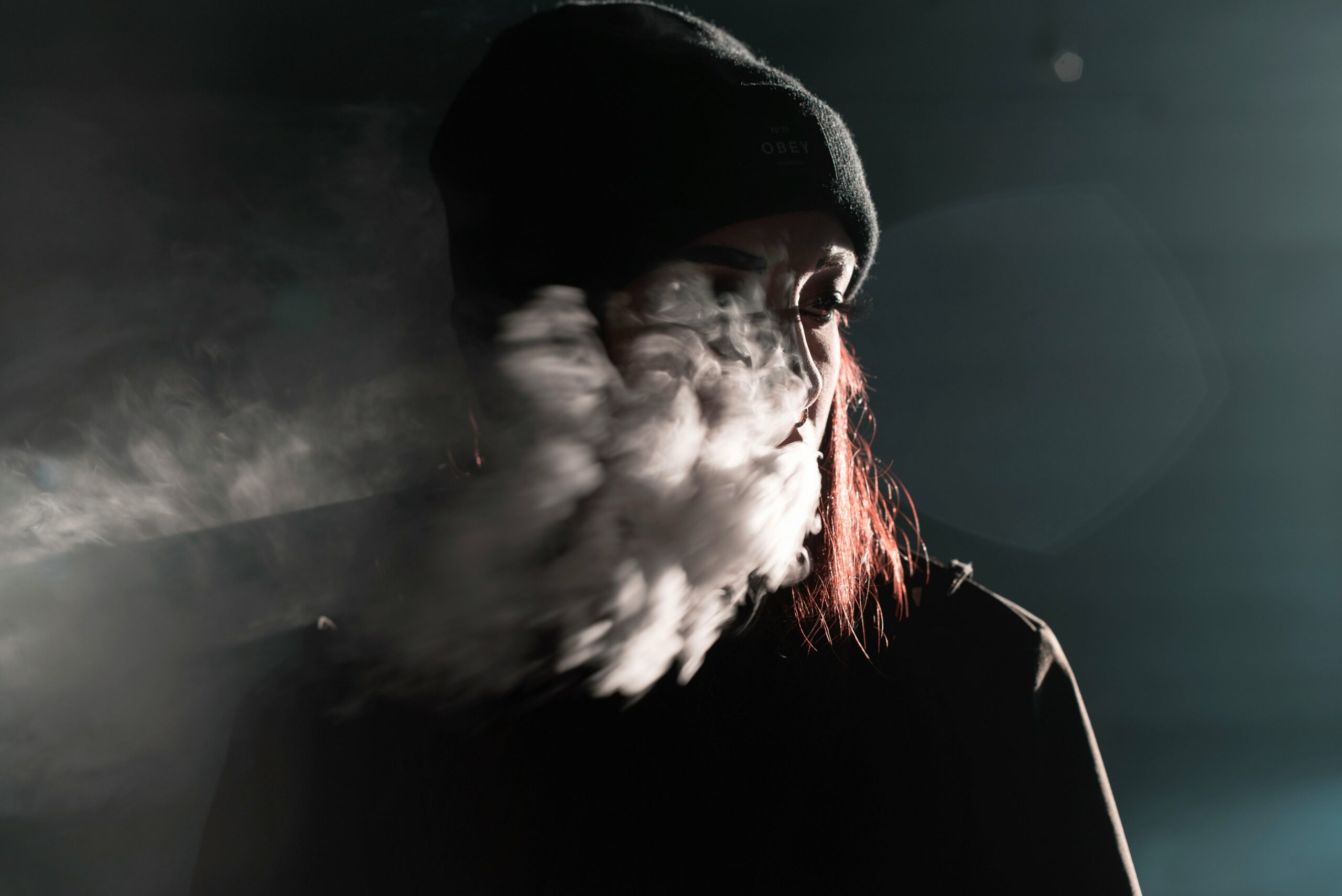 Man stressed next to broken-down car with smoke coming from hood