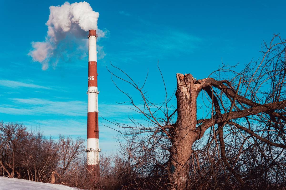 a factory pipe emits steam into the sky